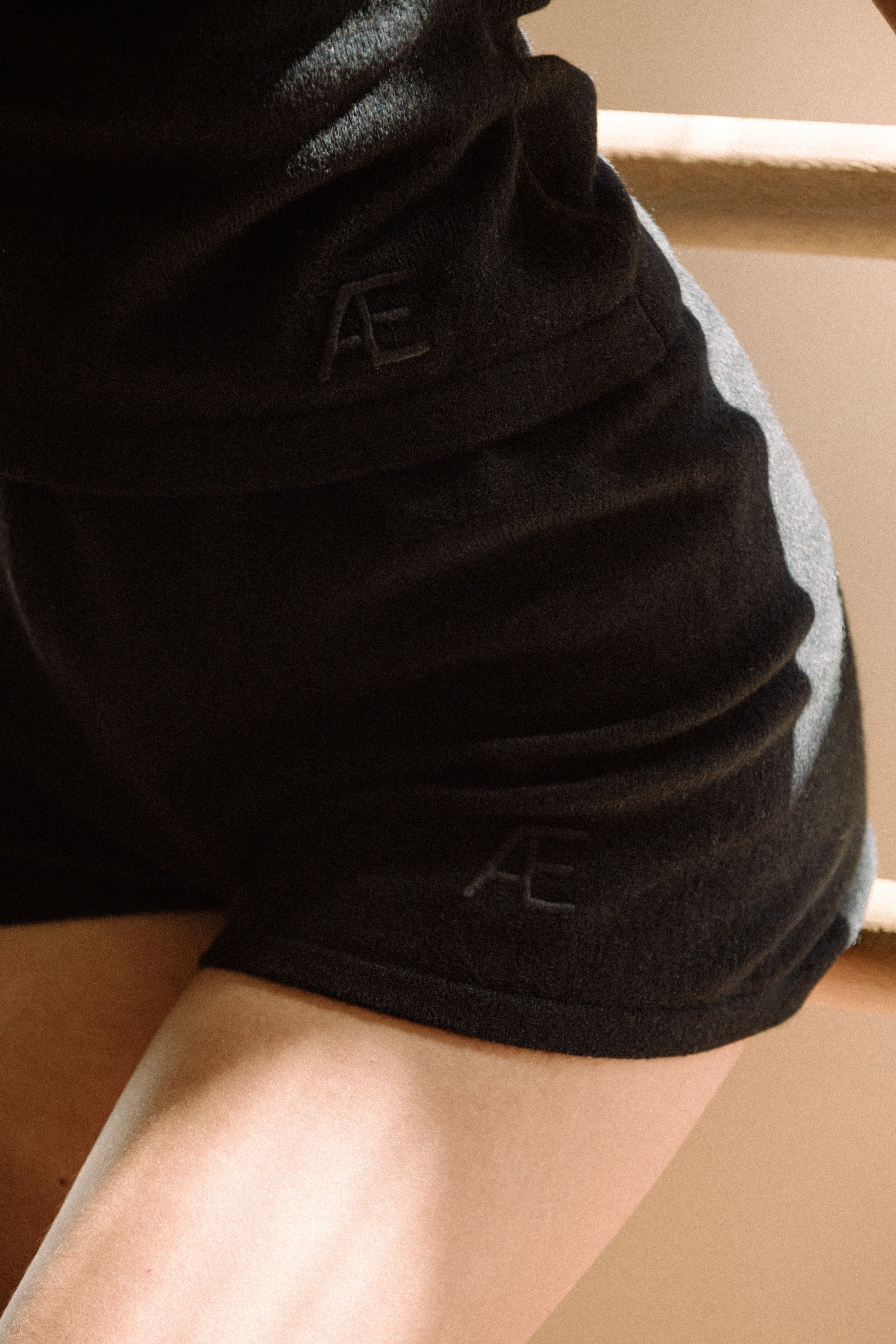 Woman wearing black shorts with embroidered logo in a dance studio